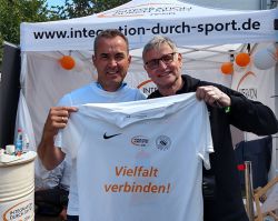 Uwe Koch (r.) schenkte Landrat Torsten Uhe dieses T-Shirt mit dem Motto der Sparkassen Fairplay Soccer Tour 2022. Foto: Landkreis Prignitz