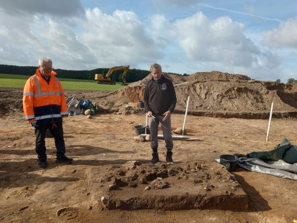 Professor Dr. Franz Schopper (l.) und Dr. Immo Heske zeigen das Pflaster aus Keramikscherben innerhalb des Hausgrundrisses.  / Foto: Landkreis Prignitz / Caroline Hähnel